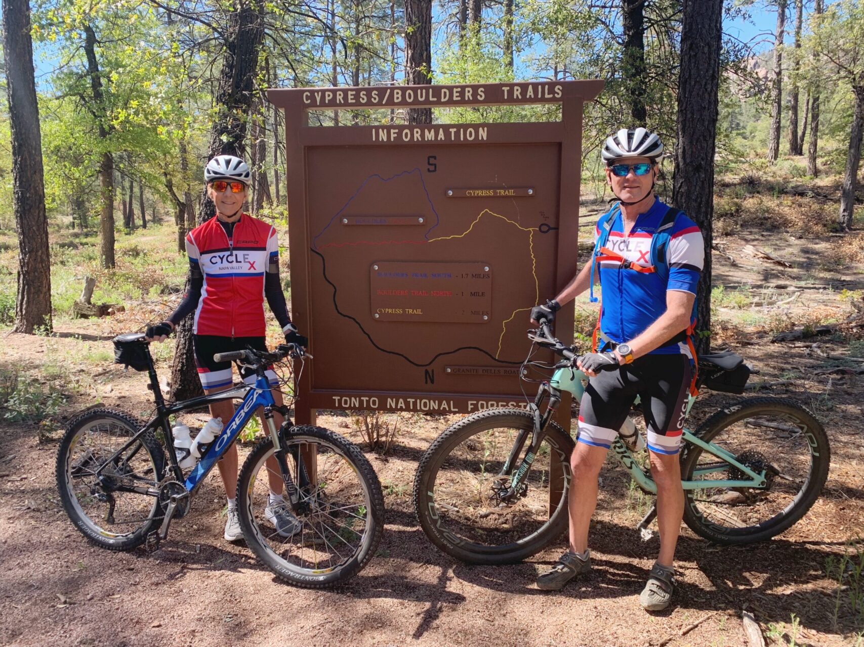 Two Payson mountain bikers in front of the trail sign.